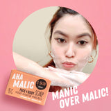 A woman is holding AHA Malic Face and Body Soap #Glowup #Hydration #pHbalanced by S-SKIN by Snoe.