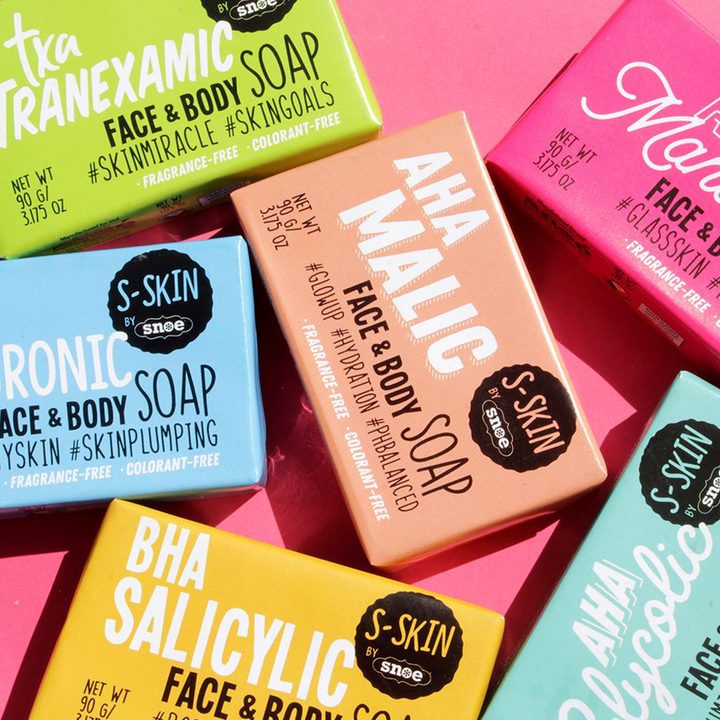 A variety of S-SKIN by Snoe HA Hyaluronic Face and Body Soaps on a pink background. #dewyskin #skinplumping