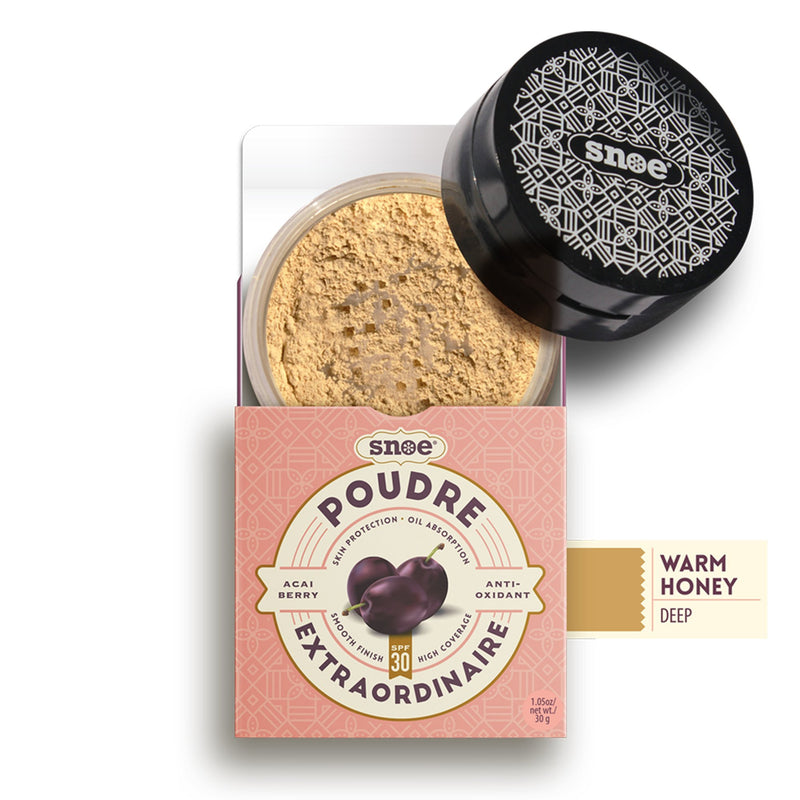 This beauty essential, called "Loose Powder SPF 30+ in WARM HONEY" by POUDRE EXTRAORDINAIRE, is a honey-colored makeup powder visible through its clear lid. It comes packaged in a peach box decorated with dark purple acai berries and features text highlighting attributes such as "Poudre Extraordinaire," "Acai Berry," "Antioxidant," and "SPF 30." The black lid is designed with a geometric pattern.