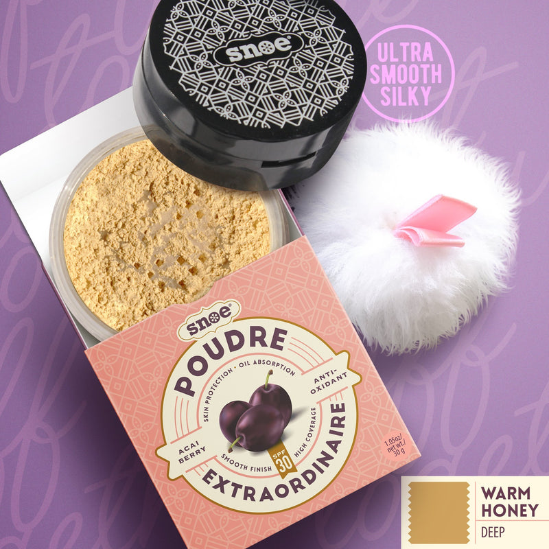 An open container of POUDRE EXTRAORDINAIRE Loose Powder SPF 30+ in WARM HONEY reveals light brown makeup powder. The beauty packaging, decorated with acai berry images, emphasizes benefits such as pore protection and oil absorption. Alongside it lies a fluffy white application puff with a pink ribbon against the purple background with text.