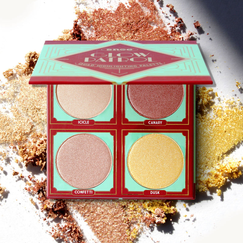 Presenting the Quad Highlighting Palette from GLOW PATROL, an open beauty palette with four shimmering highlighter shades: Icicle, Canary, Confetti, and Dusk. The make-up packaging features a geometric design in red and mint green, set against a textured backdrop of blended gold, bronze, and copper powders.